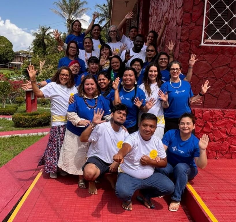 Foto de grupo das lideranças participantes do Cuidadores de Comunidade, com as mãos levantadas.